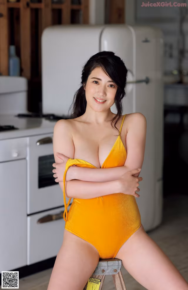 A woman in a yellow bathing suit posing for a picture.