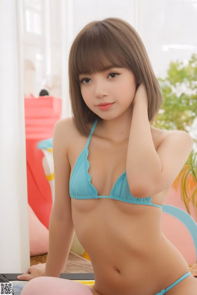 A woman in a blue bikini sitting on a bed.