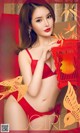 A woman in a red lingerie holding a red lantern.