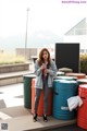 A woman standing in front of a bunch of colorful barrels.