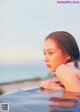 A woman in a bathtub with the ocean in the background.