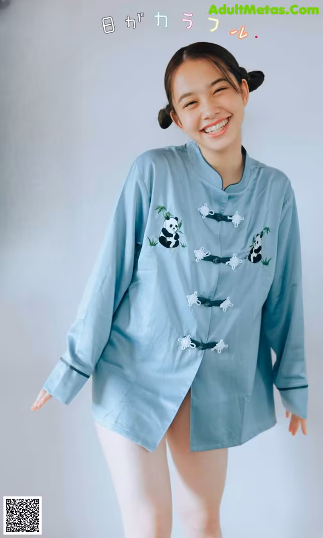 A woman wearing a blue shirt with panda embroidery on it.