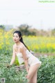 A woman in a white dress standing in a field of flowers.