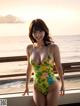 A woman in a yellow bathing suit standing on a balcony.