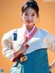 A woman in a blue and white hanbok posing for a picture.