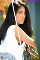 A woman with long black hair sitting on a swing.