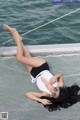 A woman laying on the deck of a boat with her legs up.