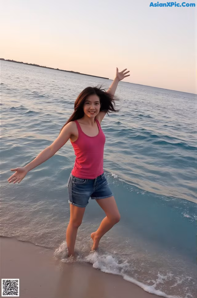 A woman standing in the ocean with her arms outstretched.
