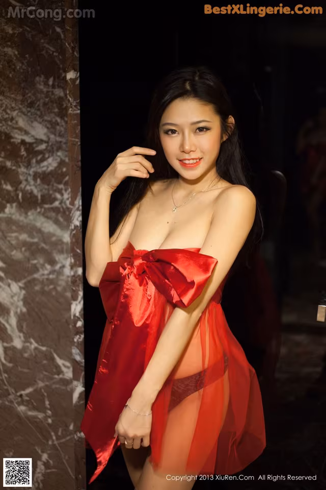 A woman in a red dress posing for a picture.