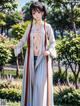 A woman in a white kimono standing in a park.