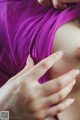 A close up of a woman's breasts with her hands on her breasts.