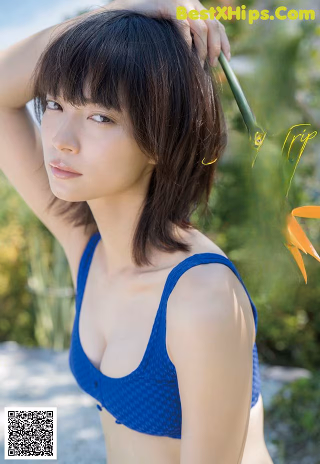 A woman in a blue bikini posing for a picture.